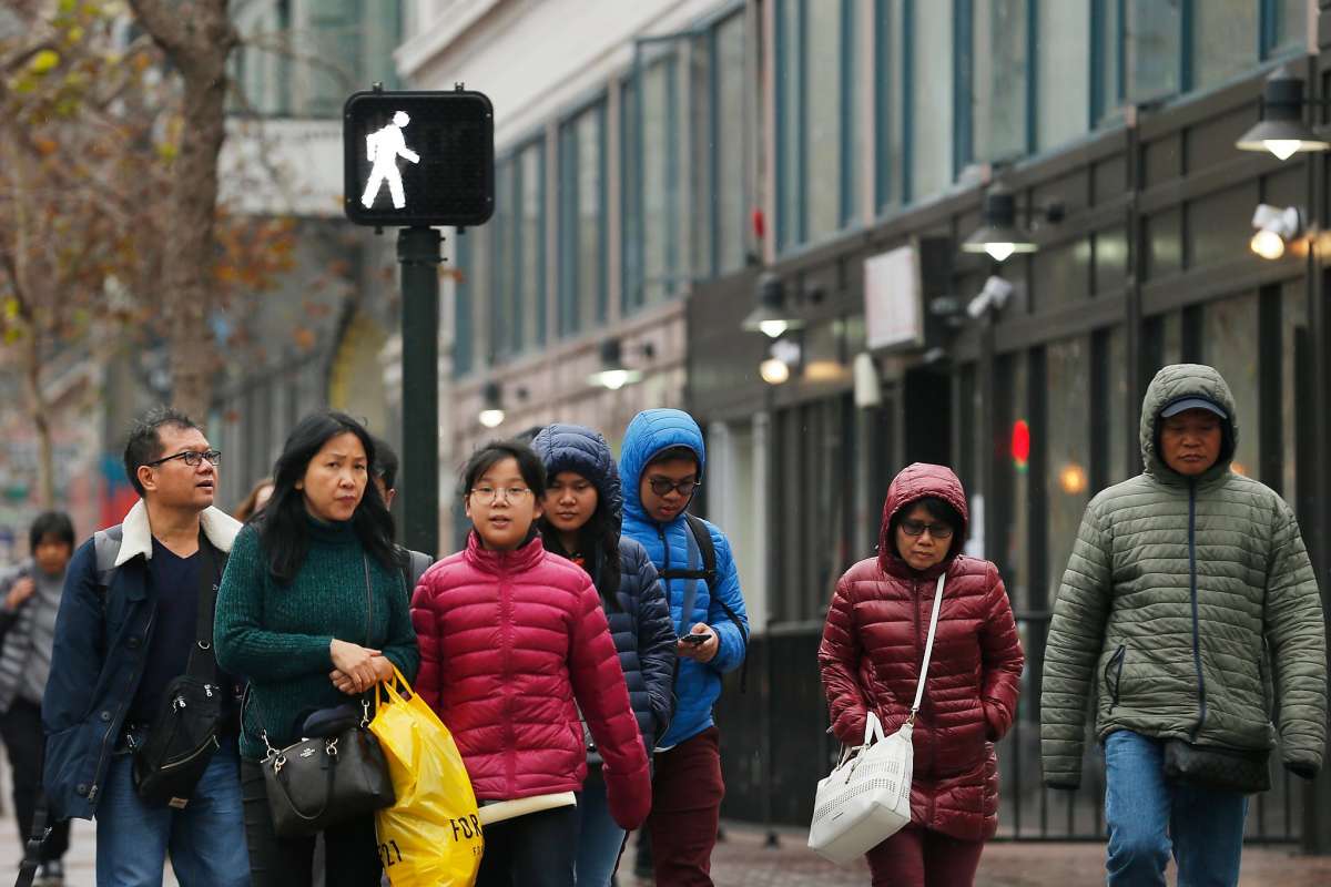 Pedestrians cross the street at Market and 6th streets